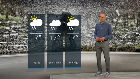 NDR Moderator Meeno Schrader steht im Studio mit der Wettervorhersage.
