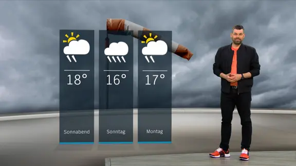 NDR Moderator Sebastian Wache steht im Studio mit der Wettervorhersage