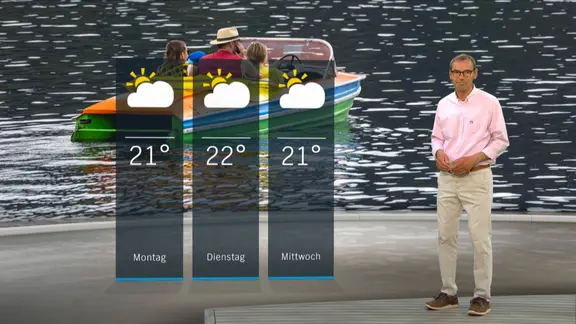 NDR Moderator Meeno Schrader steht im Studio mit der Wettervorhersage.