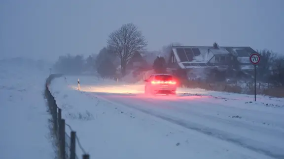 Niedersachsen, Moormerland: Am Deich sind die Straßen mit Schnee bedeckt.