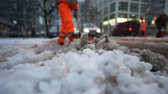 Mitarbeiter des Winterdienstes räumen den Schnee von Hamburgs Straßen. | Marcus Brandt/dpa Mitarbeiter des Winterdienstes räumen den Schnee von Hamburgs Straßen.