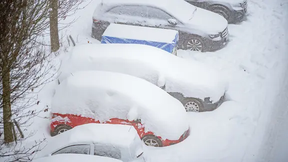 Mehrere Autos sind in einer Straße in hamburg zugeschneit.