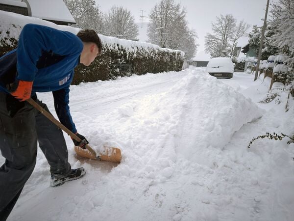 26.01.2026, Bayern, Forchheim: Ein Mann schaufelt in Forchheim Schnee von einem Bürgersteig. Foto: Daniel Löb/dpa +++ dpa-Bildfunk +++