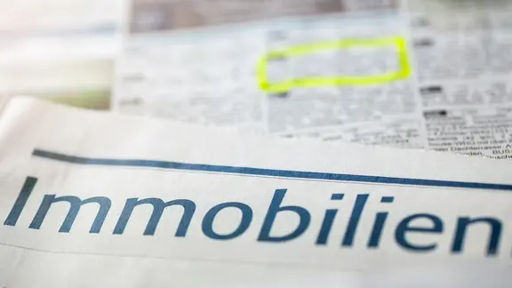 Eine Zeitung, in der Immobilien annonciert sind.