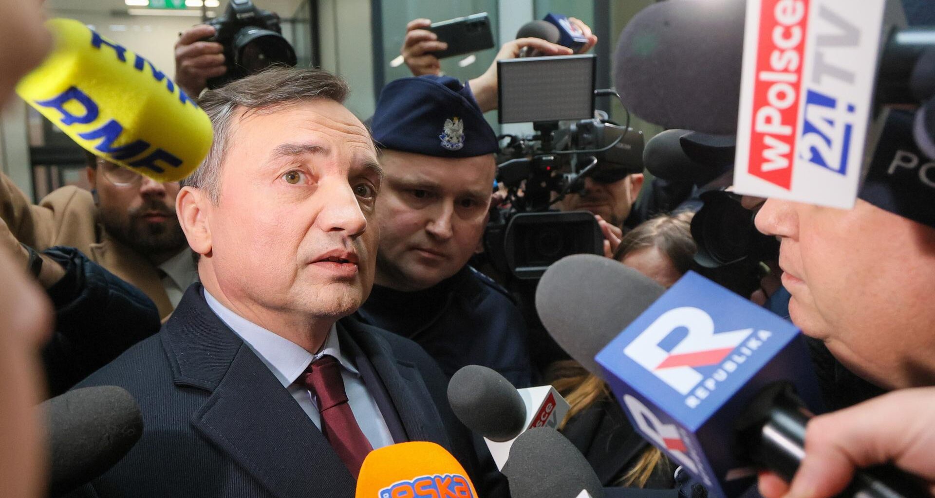 Der ehemalige polnische Justizminister Zbigniew Ziobro (l), wird beim Verlassen des "Republika"-Fernsehstudios von Journalisten mit Mikrofonen umlagert.