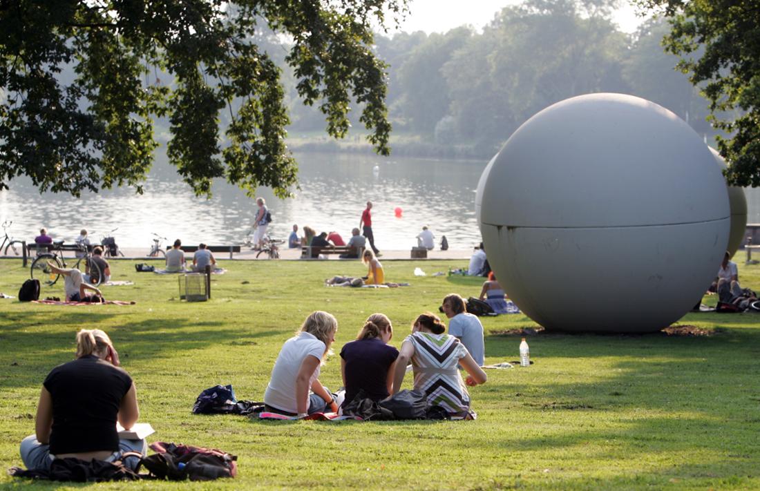 Zahlreiche Besucher sitzen am Aasee in Münster. 