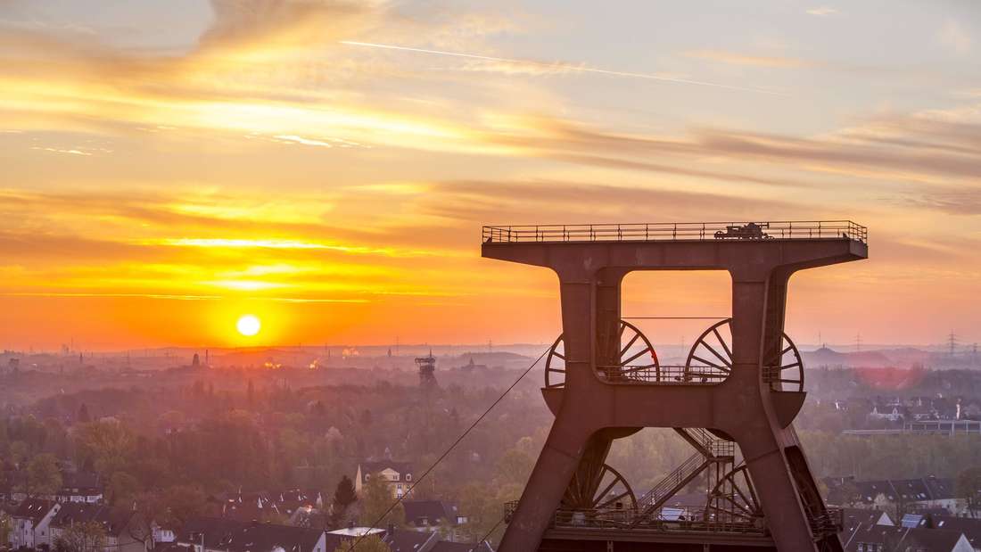 Das Welterbe Zeche Zollverein Essen bei Sonnenaufgang: Zu sehen ist das Fördergerüst Schacht 12.