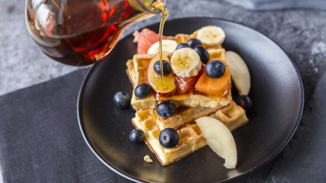 Ahornsirup auf Pfannkuchen gegossen