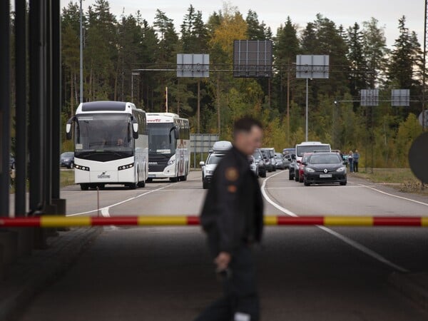 Ein Grenzschutzbeamter geht an einer Schranke vorbei, während Autos und Busse am Grenzübergang Vaalimaa darauf warten, die Grenze von Russland nach Finnland zu passieren. Nach der russischen Teilmobilisierung von 300 000 Reservisten für den Krieg gegen die Ukraine hat das Nachbarland Finnland mehr Verkehr an der gemeinsamen Grenze registriert. +++ dpa-Bildfunk +++