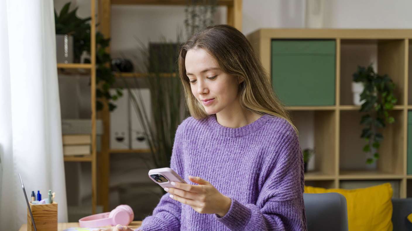Frau benutzt Smartphone im Homeoffice