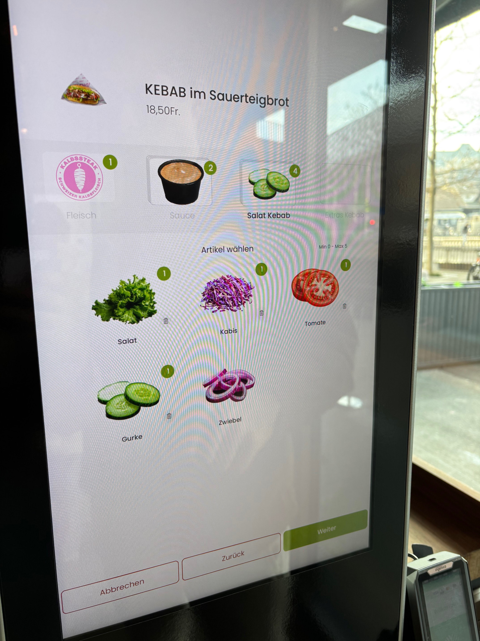 Bestellbildschirm für Kebab im Sauerteigbrot mit Zutatenwahl: Fleisch, Sauce, Salat, Kohl, Tomate, Gurke, Zwiebel. Preis 18,50 CHF.