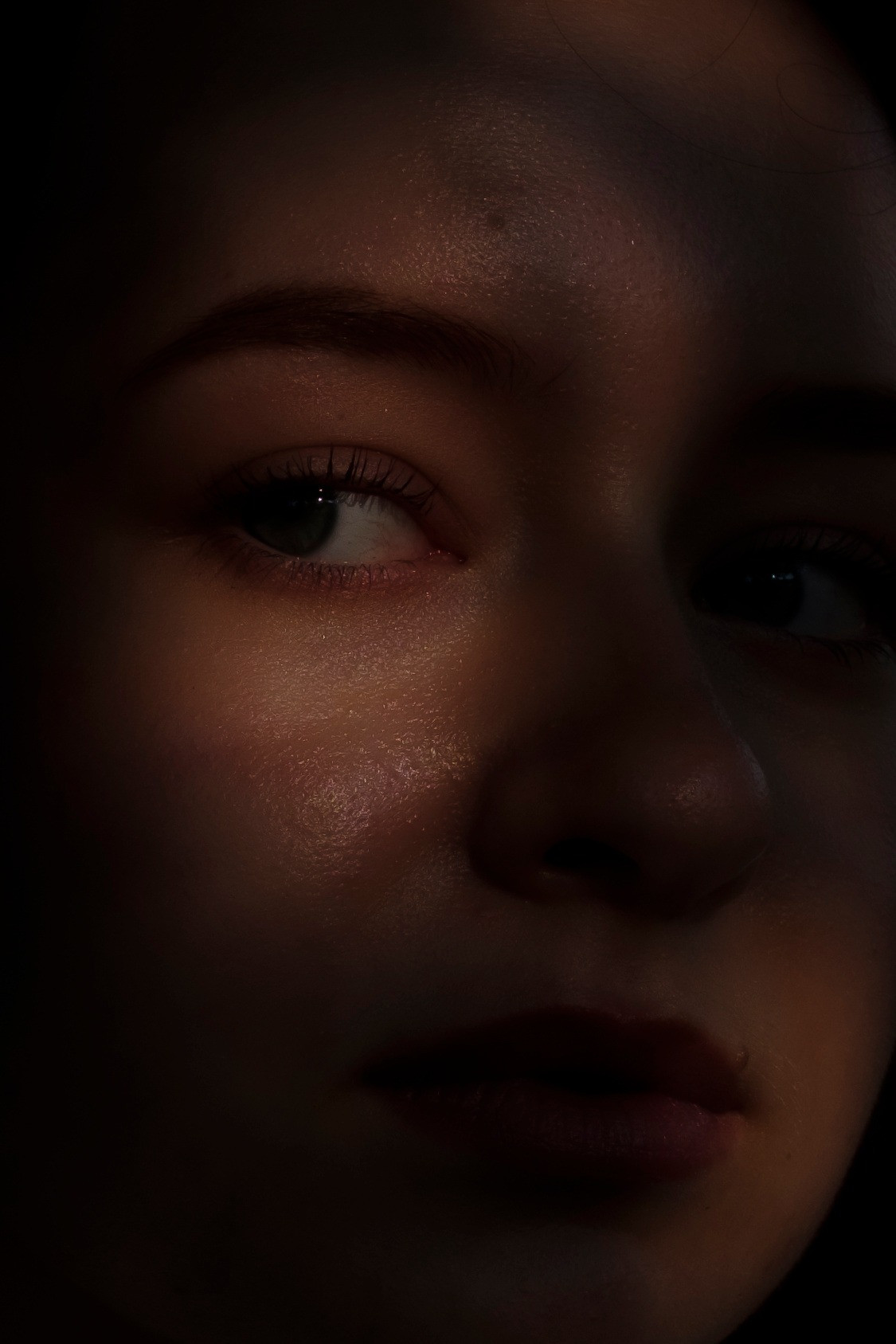 Nahaufnahme eines Gesichts mit Schatten, die stimmungsvolle Beleuchtung erzeugen.