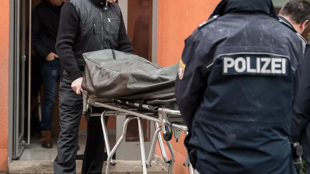 Zwei-Bestatter-schieben-am-22-01-2018-in-Darmstadt-Hessen-die-Leiche-des-erschossenen-Manns-aus-einem-Mehrfamilienhaus-Die-Polizei-hat-in-der-Nacht-zum-Montag-einen-mit-Messern-bewaffneten-Familienvater-erschossen