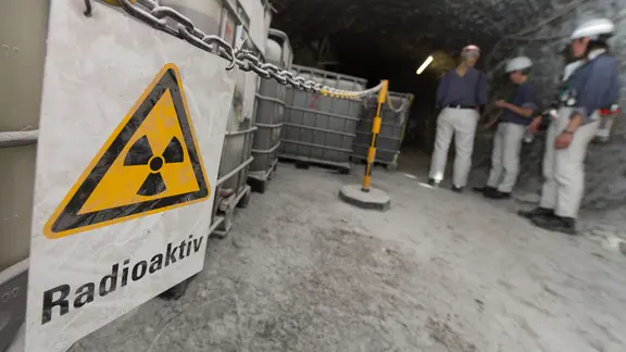 Vor Containern mit radioaktiver Lauge hängt in der Schachtanlage Asse ein Warnschild mit der Aufschrift "Radioaktiv". | picture alliance/dpa | Sebastian Gollnow Vor Containern mit radioaktiver Lauge hängt in der Schachtanlage Asse ein Warnschild mit der Aufschrift "Radioaktiv".