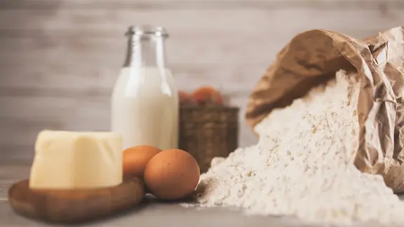 Grundzutaten für das Backen auf einem Tisch: Milch, Butter, Eier und Mehl | Colourbox, George Dolgikh Grundzutaten für das Backen auf einem Tisch: Milch, Butter, Eier und Mehl