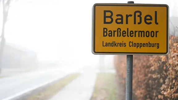 Bei der Suche nach den beiden Kindern konzentriert sich die Polizei momentan auf den Bereich Barßel und Barßelermoor. | Lars Penning/dpa Das Ortsschild von Barßel im Nebel.