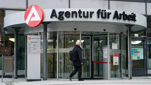 Ein Mann geht zum Eingang vom Arbeitsamt Hamburg. | picture alliance /ABBfoto Ein Mann geht zum Eingang vom Arbeitsamt Hamburg.