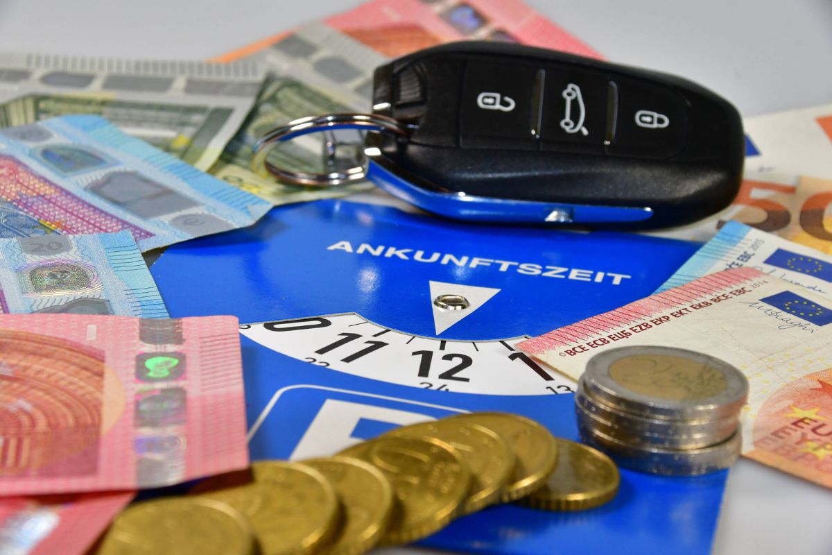 Eine Parkscheibe liegt unter jeder Menge Bargeld. Symbolbild für Falschparken.