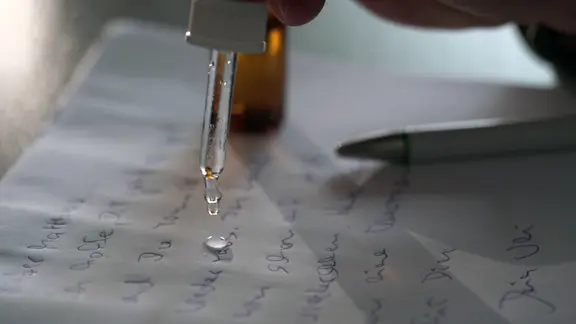 Mit einer Pipette wird eine Flüssigkeit auf Papier geträufelt - so gelangen Drogen an Häftlinge. | NDR Mit einer Pipette wird eine Flüssigkeit auf Papier geträufelt.