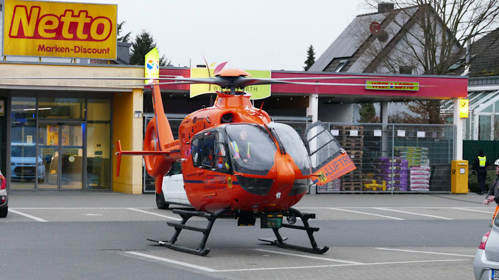 Ein Rettungshubschrauber landet auf dem nahegelegenen Supermarkt-Parkplatz
