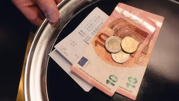 Ein silbernes Kelnertablett auf dem eine Rechnung und Bargeld liegt | AdobeStock/Medienzunft Berlin Ein silbernes Kelnertablett auf dem eine Rechnung und Bargeld liegt