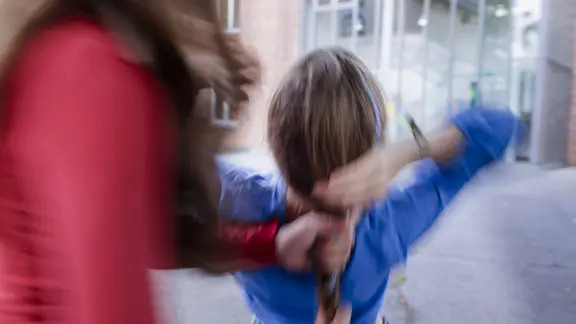 Eine Person zieht ein Kind an den Haaren | IMAGO / photothek Eine Person zieht ein Kind an den Haaren