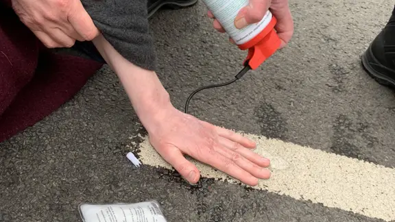 Ein Aktivist der Gruppe "Letzte Generation" hat seine Hand auf eine Straße geklebt. | NDR, Anna Schlieter Ein Aktivist der Gruppe "Letzte Generation" hat seine Hand auf eine Straße geklebt.
