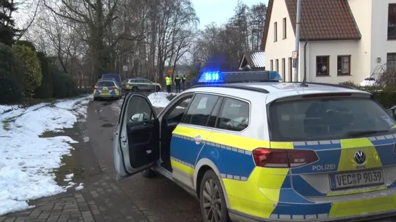 Mehrere Polizeiautos stehen in Lohne nachdem ein Mann von einem Hunde getötet wurde.