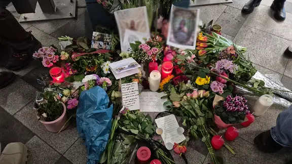 Viele Menschen haben an der Unglücksstelle Blumen und Kerzen niedergelegt. | NDR Blumensträuße, Kerzen und Karten liegen an der U-Bahn-Station Wandsbek Markt.