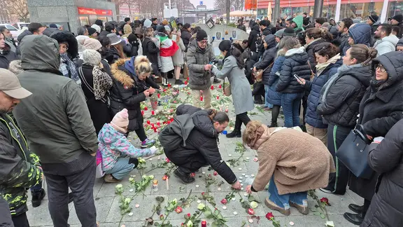 Menschen legen Blumensträuße und Kerzen an der Station Wandsbek Markt nieder. | NDR Menschen legen Blumensträuße und Kerzen an der Station Wandsbek Markt nieder.