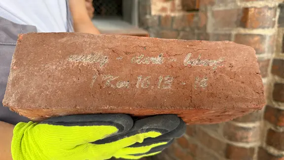 Ein roter Ziegelstein mit der Inschrift: 1 Kor. 16.13-14 | NDR Ein roter Ziegelstein mit der Inschrift: 1 Kor. 16.13-14