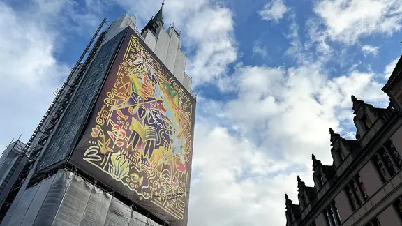 Ein Baugerüst an der Marktkirche ist einem großflächigen Bild des Künstlers Sebastian Peetz geschmückt. | NDR, Kristina Hoffmann Ein Baugerüst an der Marktkirche ist einem großflächigen Bild des Künstlers Sebastian Peetz geschmückt.