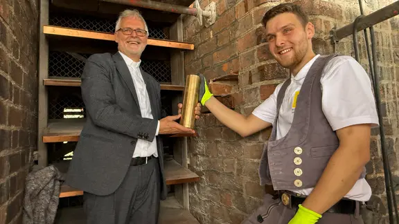 Zwei Personen halten eine goldfarbene Zeitkapsel in der Hand. | NDR/ Niels Kristoph Zwei Personen halten eine goldfarbene Zeitkapsel in der Hand.