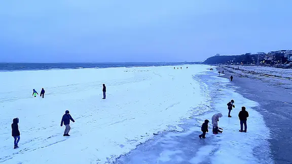 Viele Menschen laufen auf der zugefrorenen Ostsee in Scharbeutz. | Julian Marxen Viele Menschen laufen auf der zugefrorenen Ostsee in Scharbeutz.