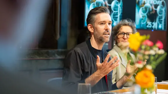"Liebe will riskiert werden" lautet das Motto der neuen Spielzeit, die auch der Beginn der Intendanz von Vasco Boenisch sein wird. | Schauspiel Hannover, Moritz Küstner Ein Mann redet und gestikuliert mit der Hand. Es ist Intendant Vasco Boenisch.