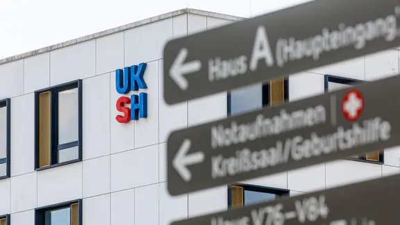 Blick auf das UKSH-Logo am Hauptgebäude des Universitätskrankenhauses Lübeck | picture alliance/dpa, Markus Scholz Blick auf das UKSH-Logo am Hauptgebäude des Universitätskrankenhauses Lübeck