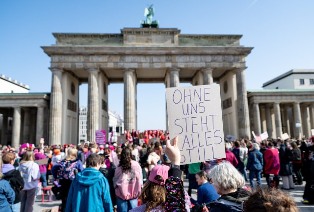 Eine Frau hält beim Aufruf zum weltweiten Frauen-Generalstreik bei einer Demonstration vor dem Brandenburger Tor ein Schild mit der Aufschrift »ohne uns steht alles still« hoch.