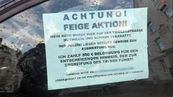 Ein Autofahrer sucht mit einem Schild selbst Zeugen einer Sachbeschädigung.