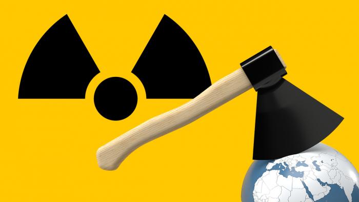 Axt mit einem der Strahlen des Atomwarnzeichens als Blatt zerhackt Globus