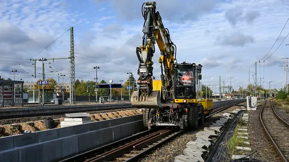 Ein Bagger steht bei Bauarbeiten auf den Schienen einer Bahnstrecke. | picture alliance/dpa, Jens Kalaene Ein Bagger steht bei Bauarbeiten auf den Schienen einer Bahnstrecke.