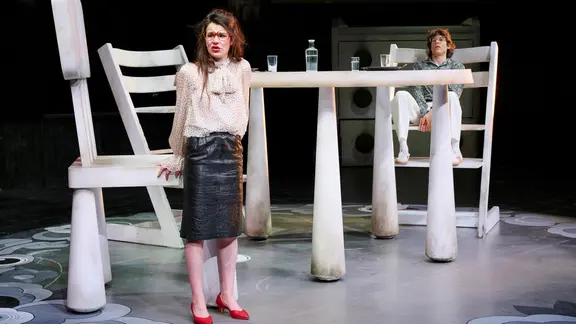 Eine Frau und ein Mann in einem Raum mit riesigen Möbeln. | Thalia Theater, Katrin Ribbe Eine Frau und ein Mann in einem Raum mit riesigen Möbeln.