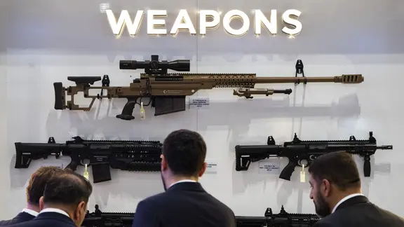 Besucher betrachten Waffen, die auf der Defence and Security Equipment International London ausgestellt sind. | picture alliance/dpa/PA Wire | Ben Whitley Besucher betrachten Waffen, die auf der Defence and Security Equipment International London ausgestellt sind.