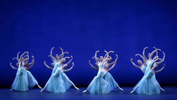 Ballett-Tänzerinnen im hellen Kleid auf der dunkelblauen Bühne im Hamburger Ballett