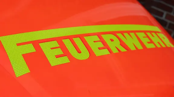 Schriftzug "Feuerwehr" ist auf der roten Motorhaube eines Feuerwehrautos zu sehen.
