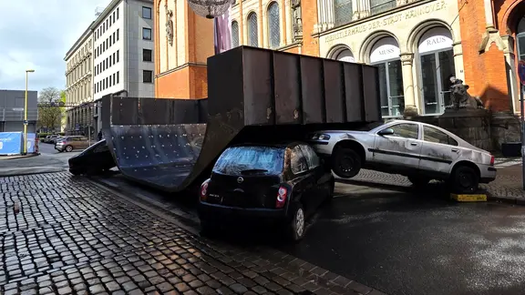 Autos liegen halb übereinander unter einer Halfpipe aus Metall