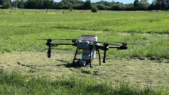 Eine Drohne für die Landwirtschaft steht auf einer Wiese.