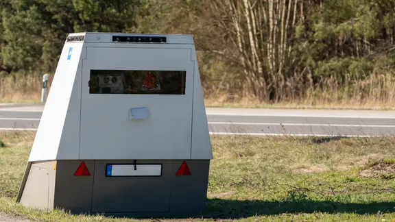 Ein mobiler Blitzer steht an einer Straße. | picture alliance / CHROMORANGE Ein mobiler Blitzer steht an einer Straße.