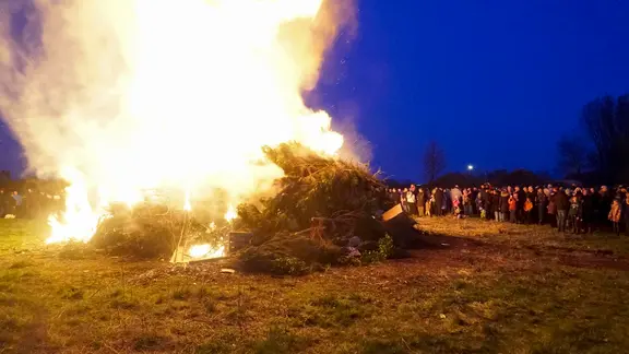 Menschen betrachten ein Osterfeuer in Hamburg. (Archivfoto) | picture alliance /ABBfoto Menschen betrachten ein Osterfeuer in Hamburg. (Archivfoto)