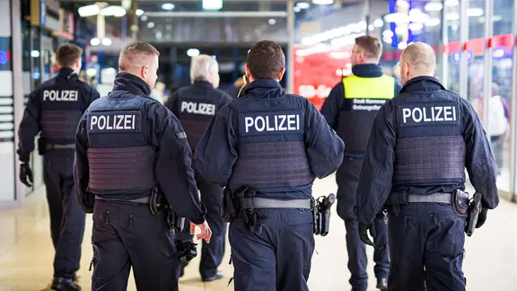 Einsatzkräfte von Bundespolizei und Ordnungsdienst gehen durch den Hauptbahnhof Hannover. | picture alliance/dpa, Moritz Frankenberg Einsatzkräfte von Bundespolizei und Ordnungsdienst gehen durch den Hauptbahnhof Hannover.