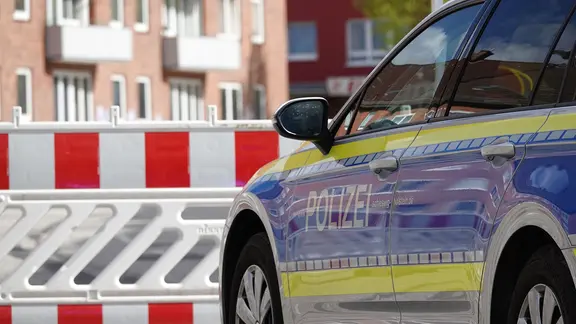 Ein Polizeifahrzeug steht vor einer Absperrung. | NDR, Carsten Salzwedel Ein Polizeifahrzeug steht vor einer Absperrung.